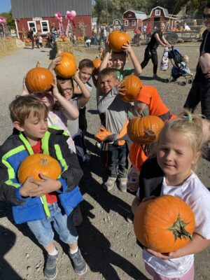 first grade students showing the pumpkins they picked out